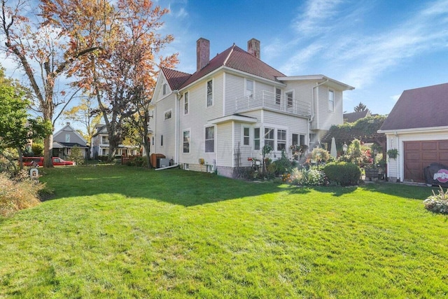 rear view of property with a yard and a garage