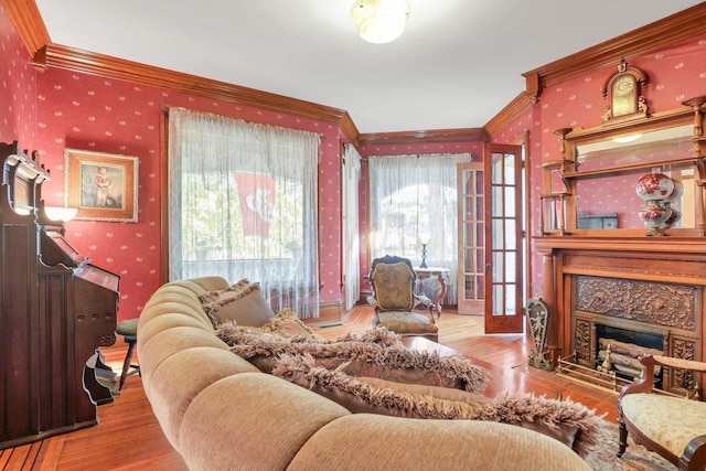 living room featuring a high end fireplace, light wood-type flooring, and ornamental molding