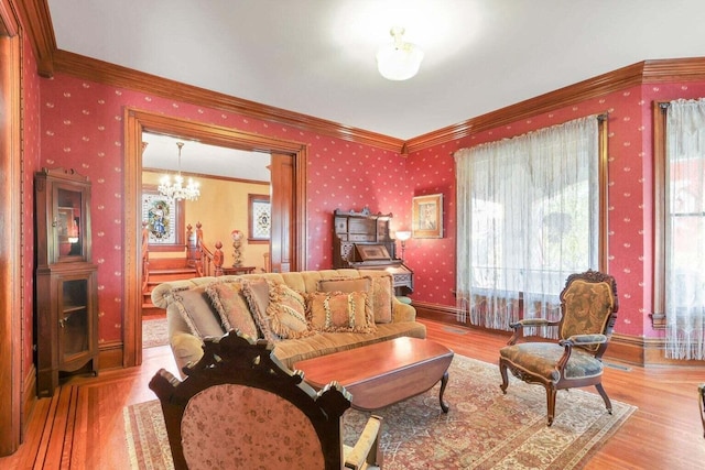 living room featuring light hardwood / wood-style floors, an inviting chandelier, and crown molding