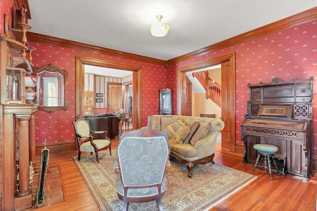 living area featuring crown molding and light hardwood / wood-style floors