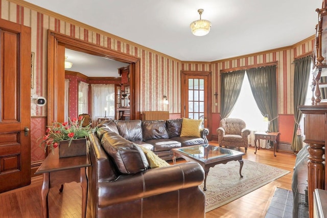 living room with crown molding and light hardwood / wood-style floors