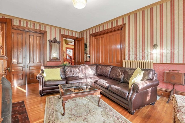 living room with radiator heating unit, lofted ceiling, and light wood-type flooring