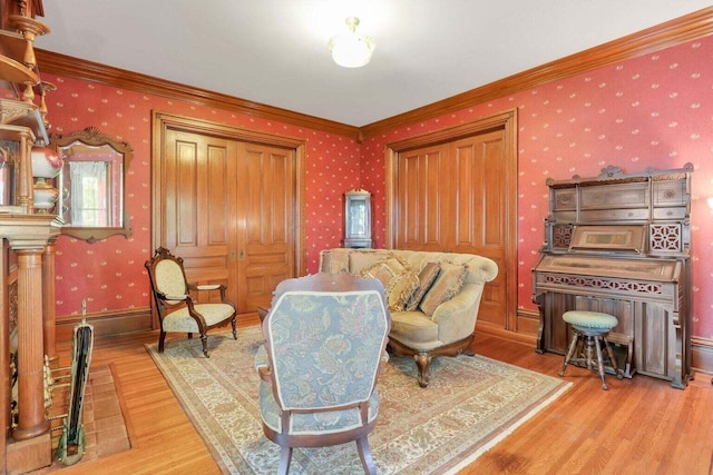 sitting room featuring crown molding and light hardwood / wood-style floors