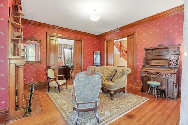 living area with hardwood / wood-style floors and crown molding