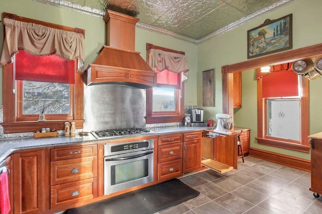 kitchen with premium range hood, stainless steel appliances, and ornamental molding