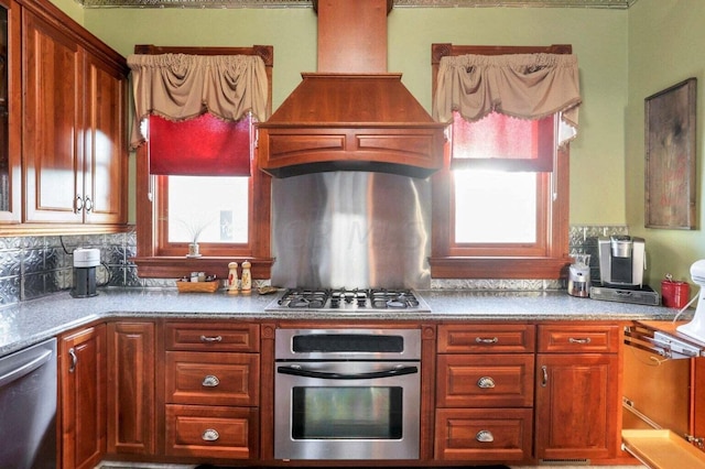 kitchen featuring custom exhaust hood, backsplash, and appliances with stainless steel finishes