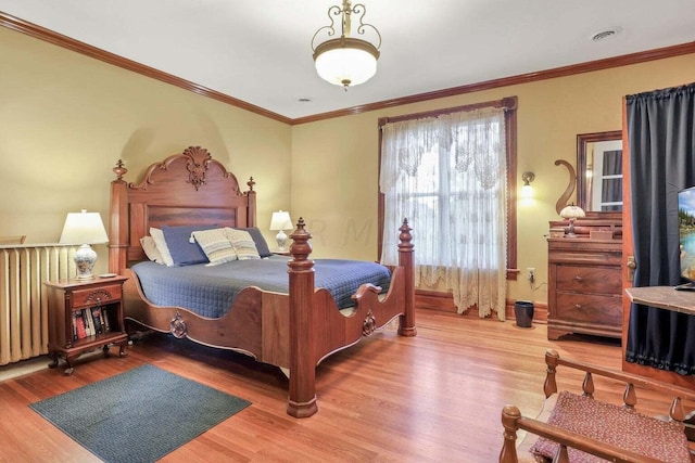 bedroom featuring light hardwood / wood-style flooring, radiator, and ornamental molding