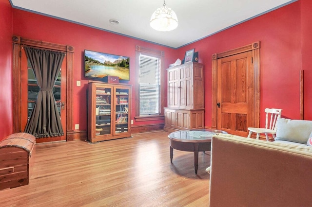 sitting room featuring light wood-type flooring and an inviting chandelier