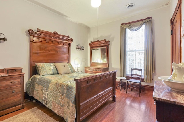 bedroom with dark hardwood / wood-style floors