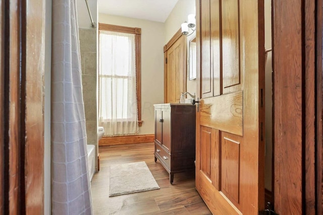 bathroom with hardwood / wood-style floors and toilet