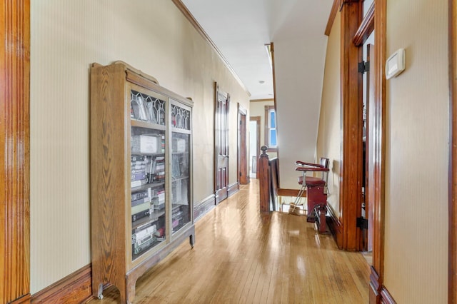 hall featuring light hardwood / wood-style flooring and crown molding