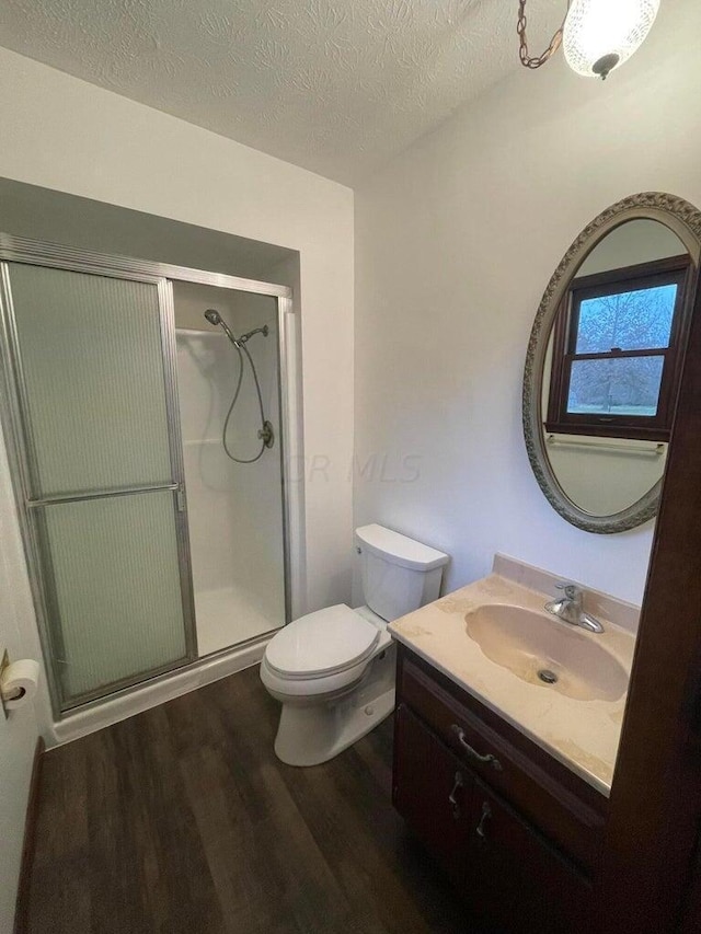 bathroom featuring vanity, a textured ceiling, hardwood / wood-style flooring, and an enclosed shower