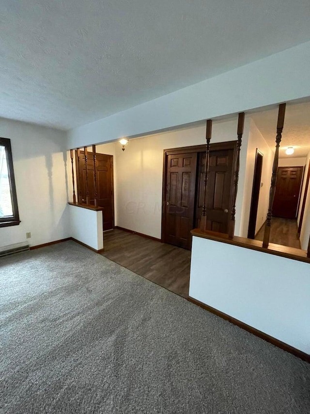 spare room with a textured ceiling and dark hardwood / wood-style floors