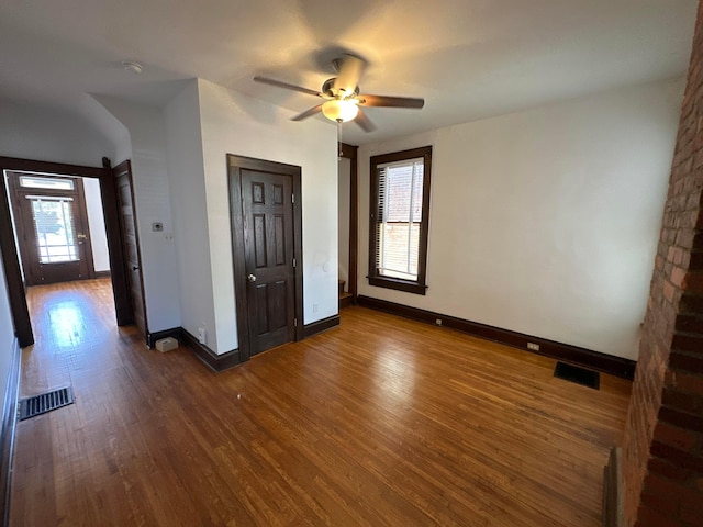 unfurnished bedroom with ceiling fan, dark hardwood / wood-style flooring, and multiple windows