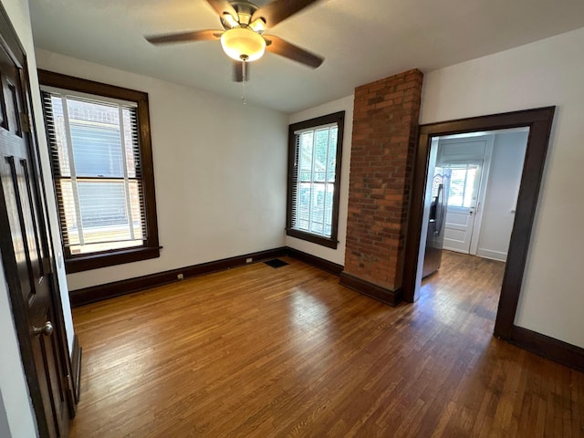 spare room featuring dark hardwood / wood-style floors, a healthy amount of sunlight, and ceiling fan