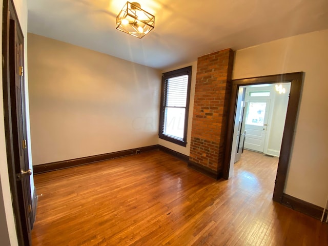 empty room featuring plenty of natural light and wood-type flooring