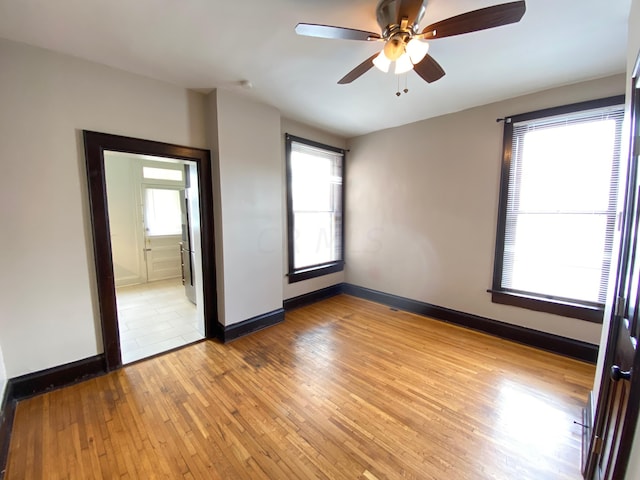 unfurnished bedroom with connected bathroom, light hardwood / wood-style floors, and ceiling fan