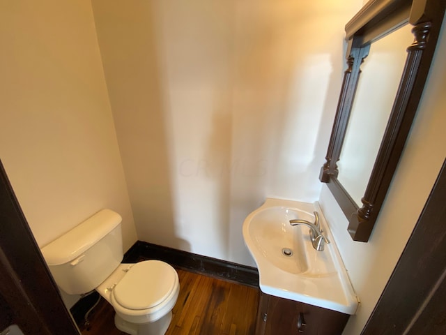 bathroom featuring vanity, wood-type flooring, and toilet