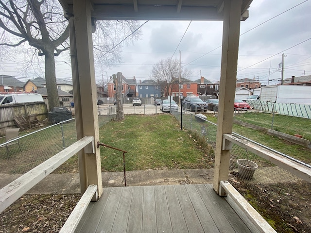 wooden deck featuring a lawn