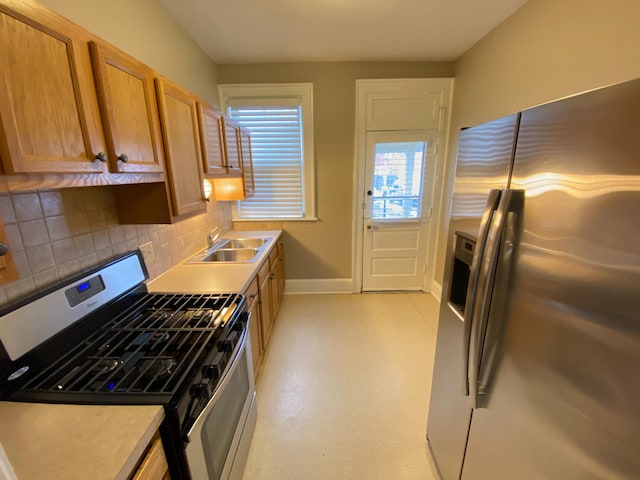 kitchen with decorative backsplash, appliances with stainless steel finishes, and sink