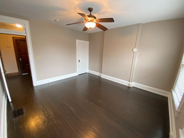 empty room with ceiling fan and dark wood-type flooring