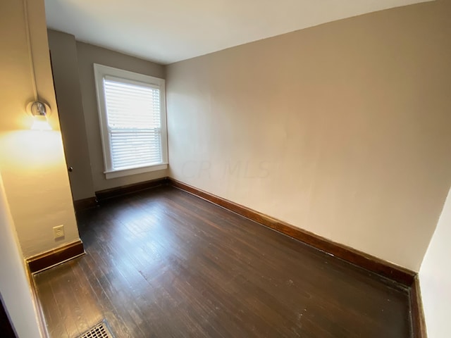 empty room with dark wood-type flooring