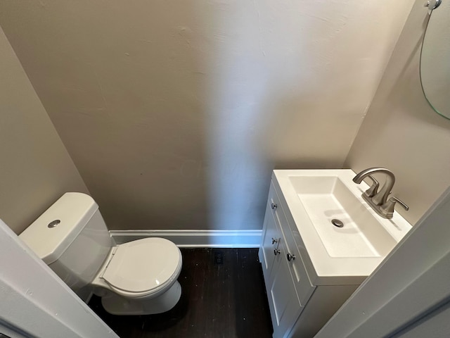 bathroom with hardwood / wood-style flooring, vanity, and toilet