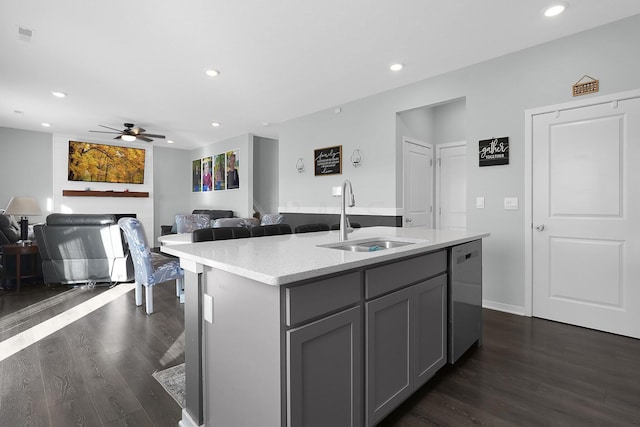 kitchen with gray cabinets, a kitchen island with sink, dishwasher, and sink