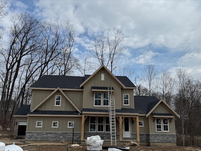 craftsman inspired home with stone siding, board and batten siding, and roof with shingles