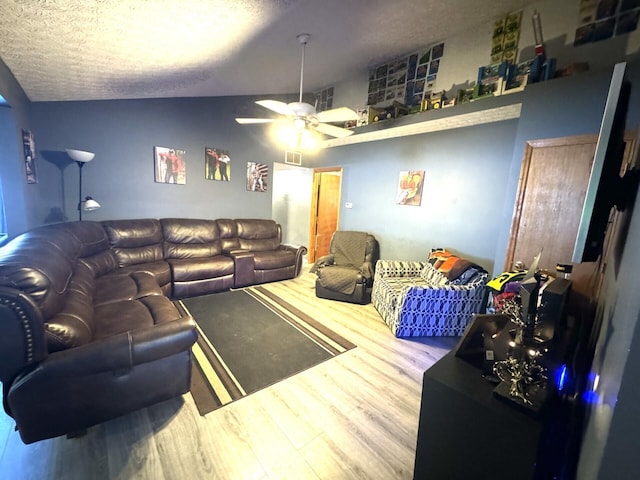 living room featuring a textured ceiling, ceiling fan, hardwood / wood-style floors, and vaulted ceiling