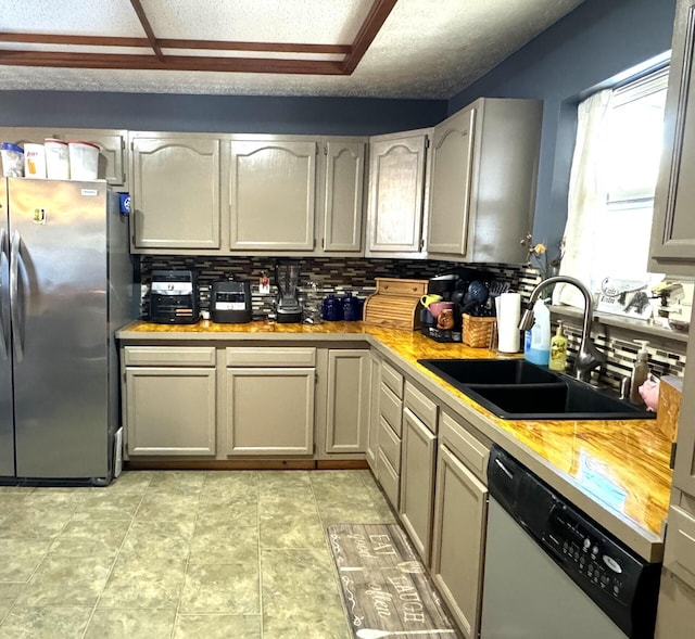 kitchen with decorative backsplash, a textured ceiling, stainless steel appliances, sink, and gray cabinets