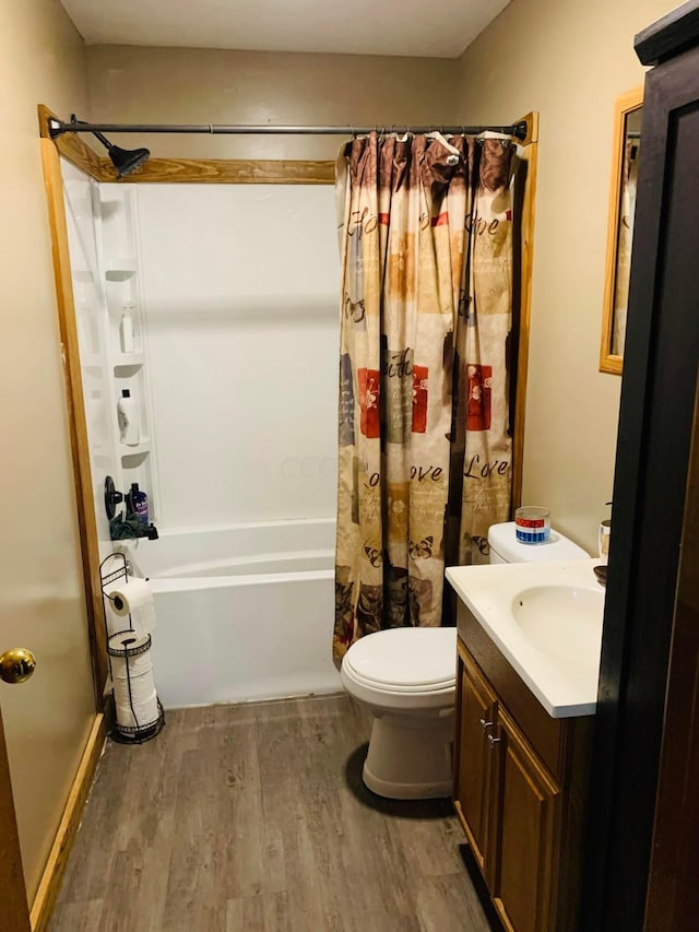 full bathroom featuring hardwood / wood-style flooring, vanity, toilet, and shower / tub combo with curtain