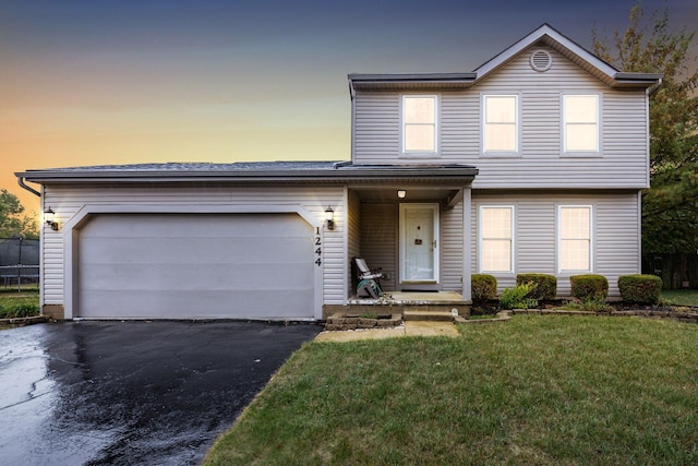 front facade featuring a lawn and a garage