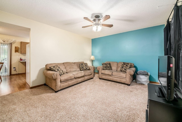 living room featuring carpet, a textured ceiling, and ceiling fan