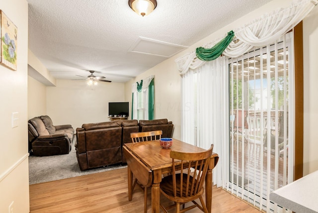 dining area with a textured ceiling, a baseboard radiator, light hardwood / wood-style flooring, and ceiling fan