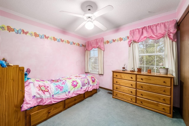 carpeted bedroom with ceiling fan and a textured ceiling