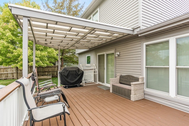 wooden deck featuring area for grilling and a pergola