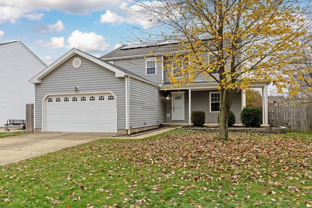 front facade featuring a front yard, solar panels, and a garage