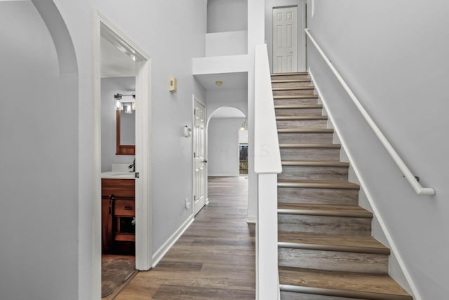 stairway featuring wood-type flooring and sink