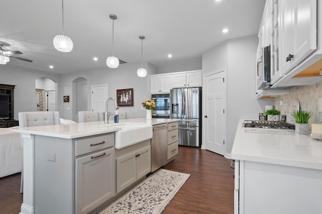 kitchen featuring a center island with sink, stainless steel appliances, dark wood-type flooring, and sink