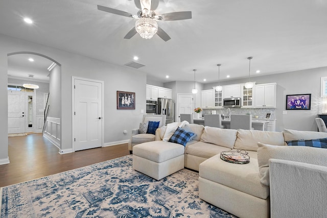 living room with dark hardwood / wood-style floors and ceiling fan