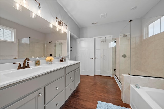 bathroom featuring hardwood / wood-style floors, vanity, and independent shower and bath