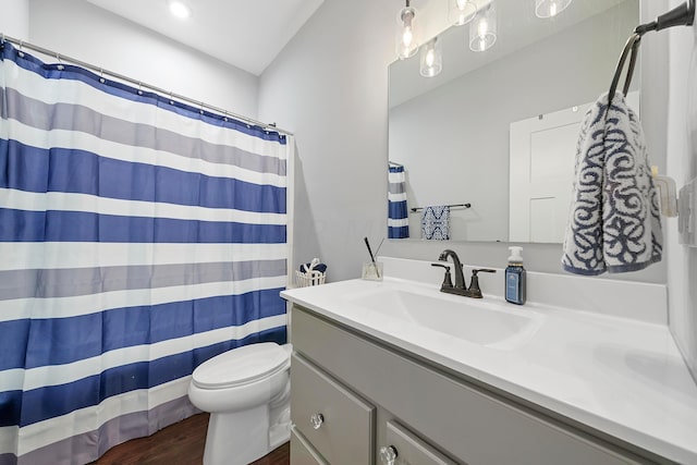 bathroom with toilet, vanity, and hardwood / wood-style flooring