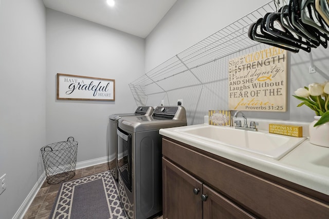 laundry area featuring cabinets, sink, washer and dryer, and dark tile patterned flooring