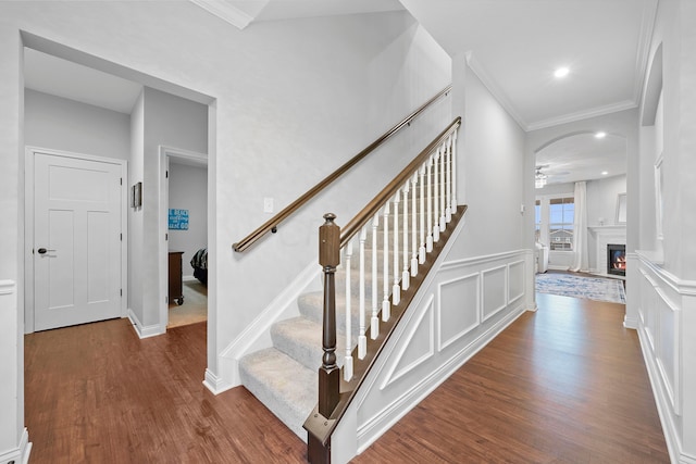 stairway featuring hardwood / wood-style flooring, ceiling fan, and crown molding