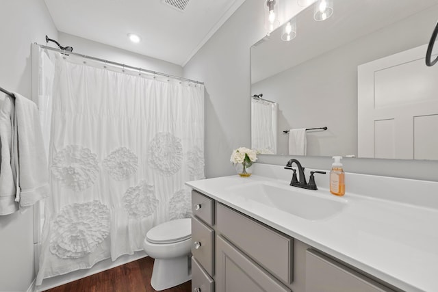 bathroom with hardwood / wood-style floors, vanity, toilet, and ornamental molding