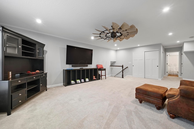 carpeted living room with crown molding and ceiling fan