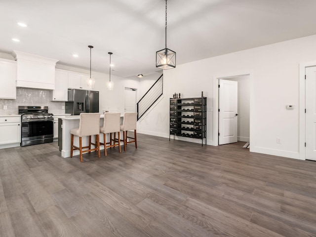 kitchen featuring white cabinetry, a center island, pendant lighting, and appliances with stainless steel finishes