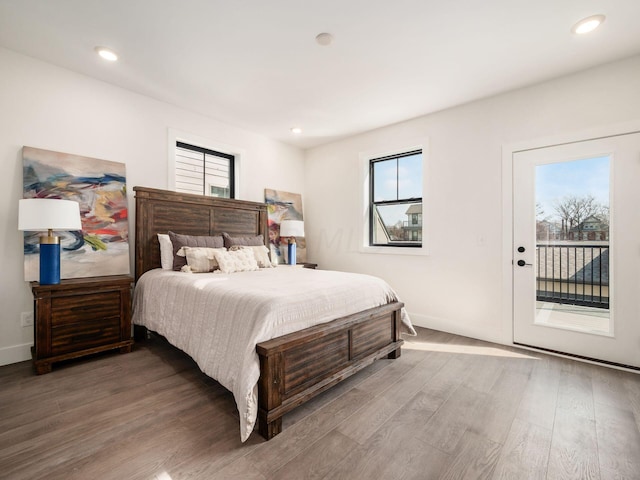 bedroom featuring access to outside, multiple windows, and hardwood / wood-style flooring