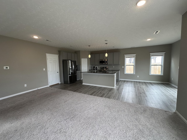 unfurnished living room featuring sink, dark hardwood / wood-style flooring, and a textured ceiling